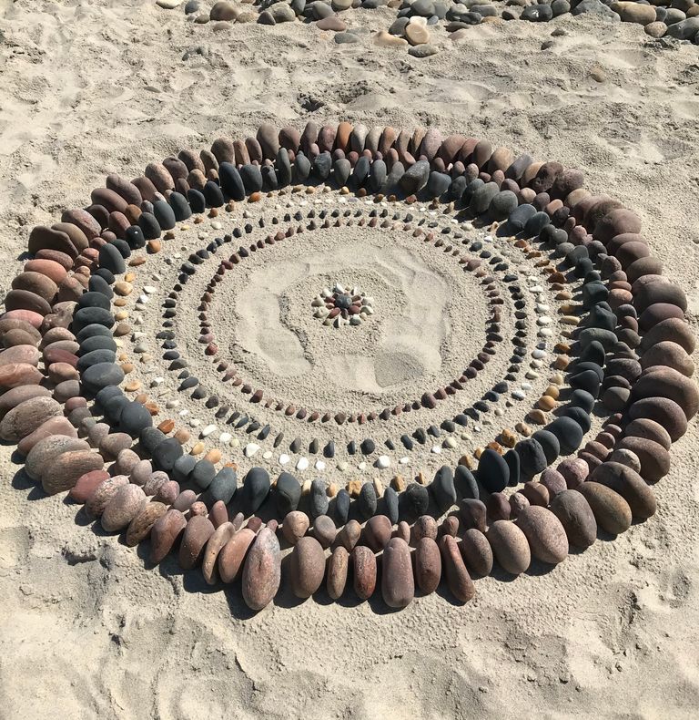 Kreise aus kleinen Steinen im Sand. Standortbestimmung
